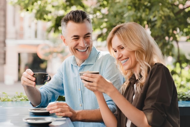 Couple laughing while looking at a phone together