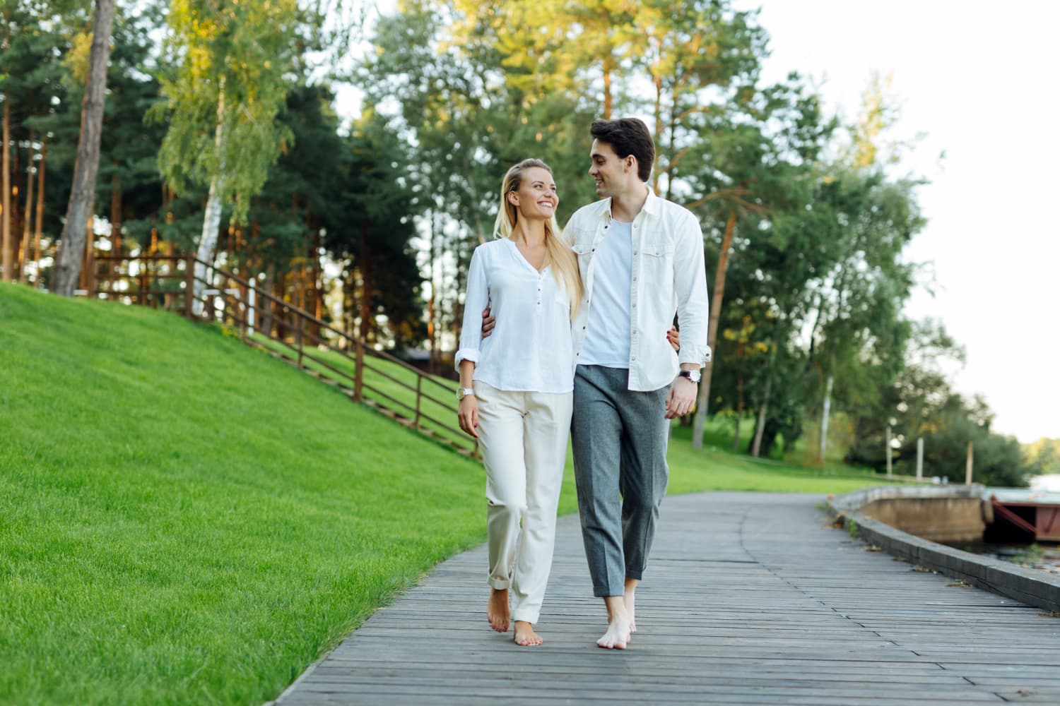 A couple walking together along a sunny park path